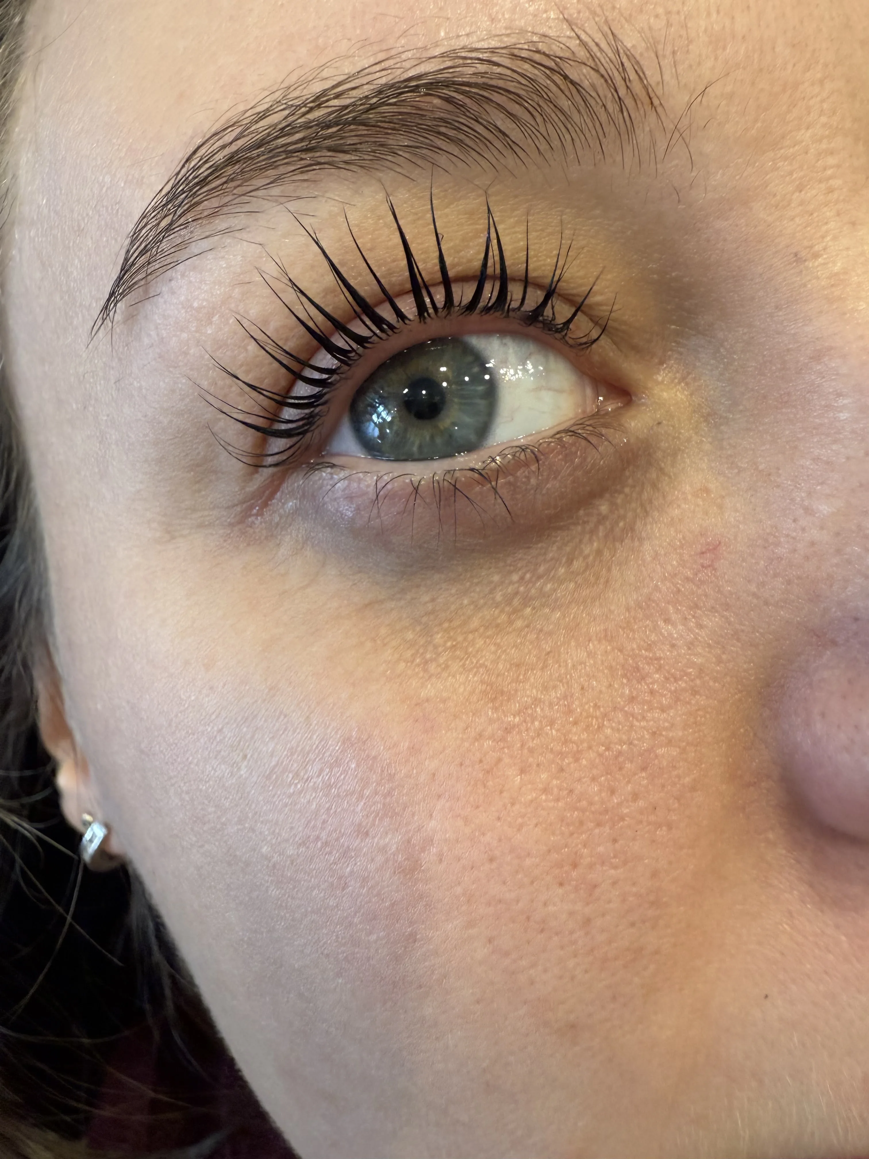 Lifted and tinted lashes over a deep-green eye — lash work by Zoma Beauty