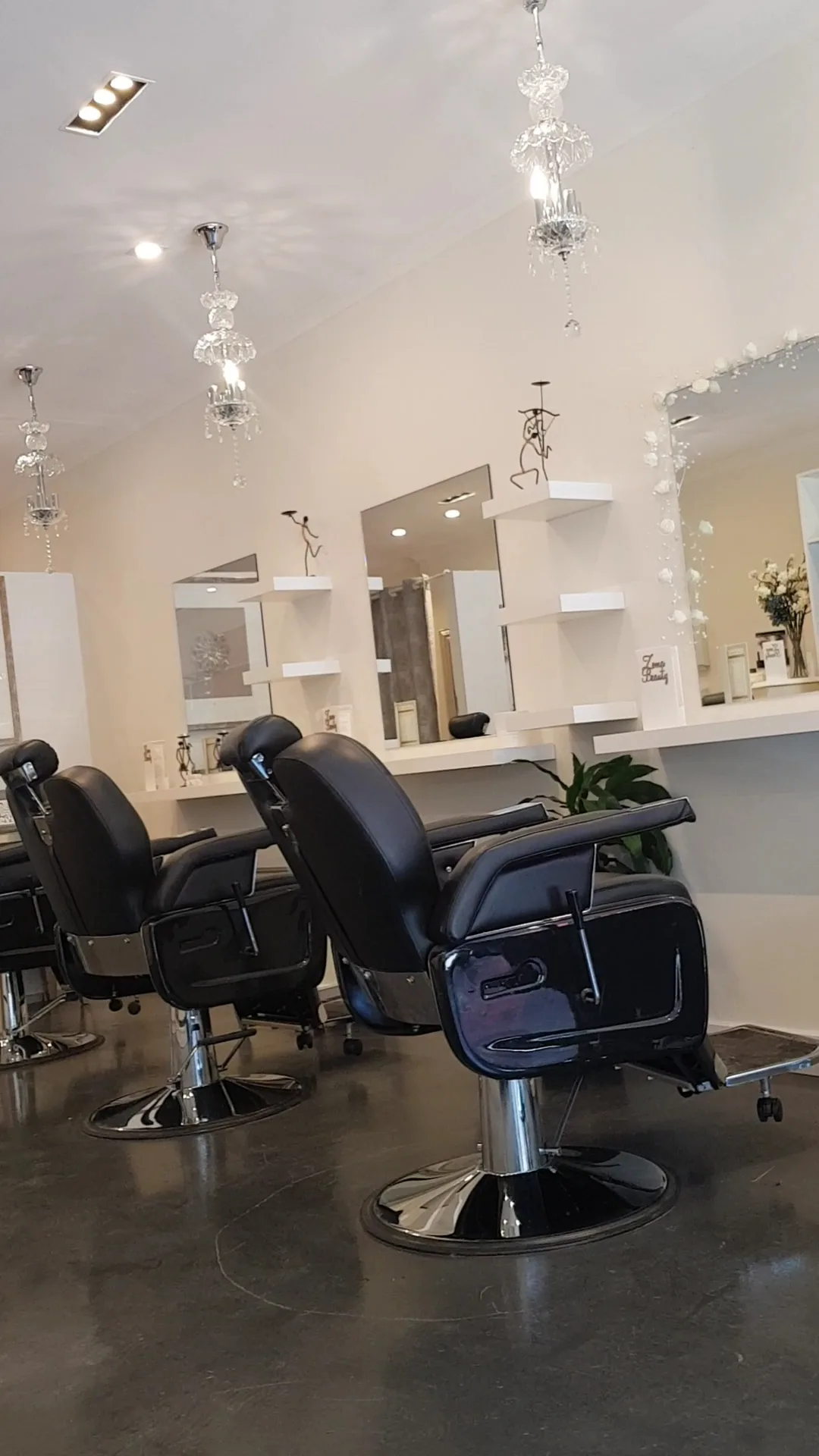 Studio interior vertical — chandeliers, black leather chairs and round mirrors