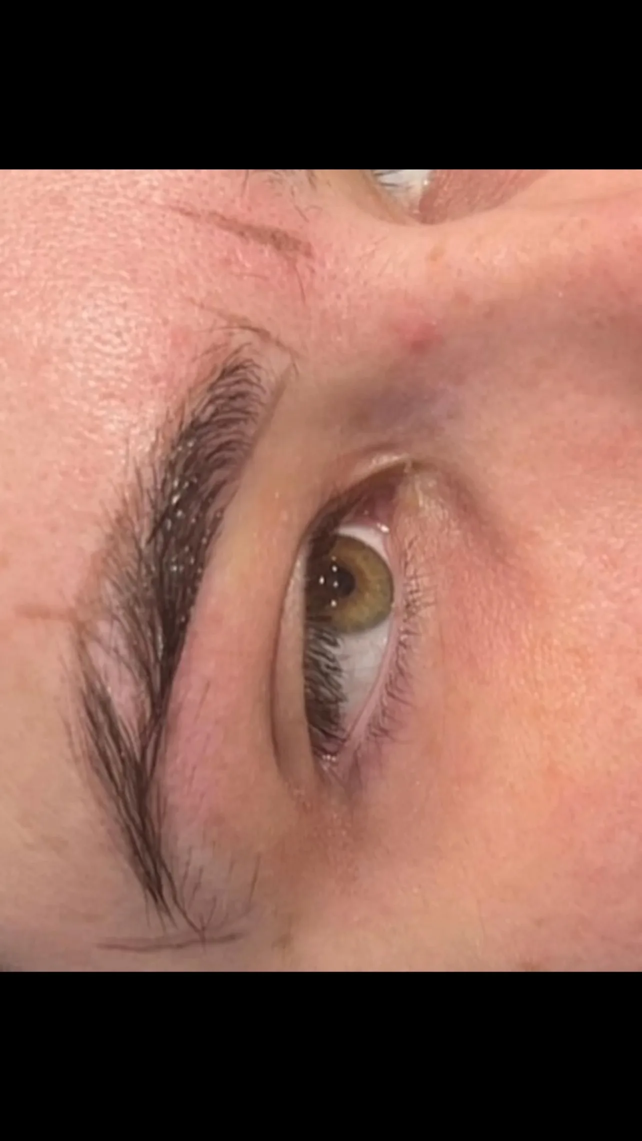 Shaped and defined brow over a hazel eye — brow work by Zoma Beauty